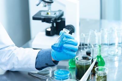 Person holding a laboratory flask